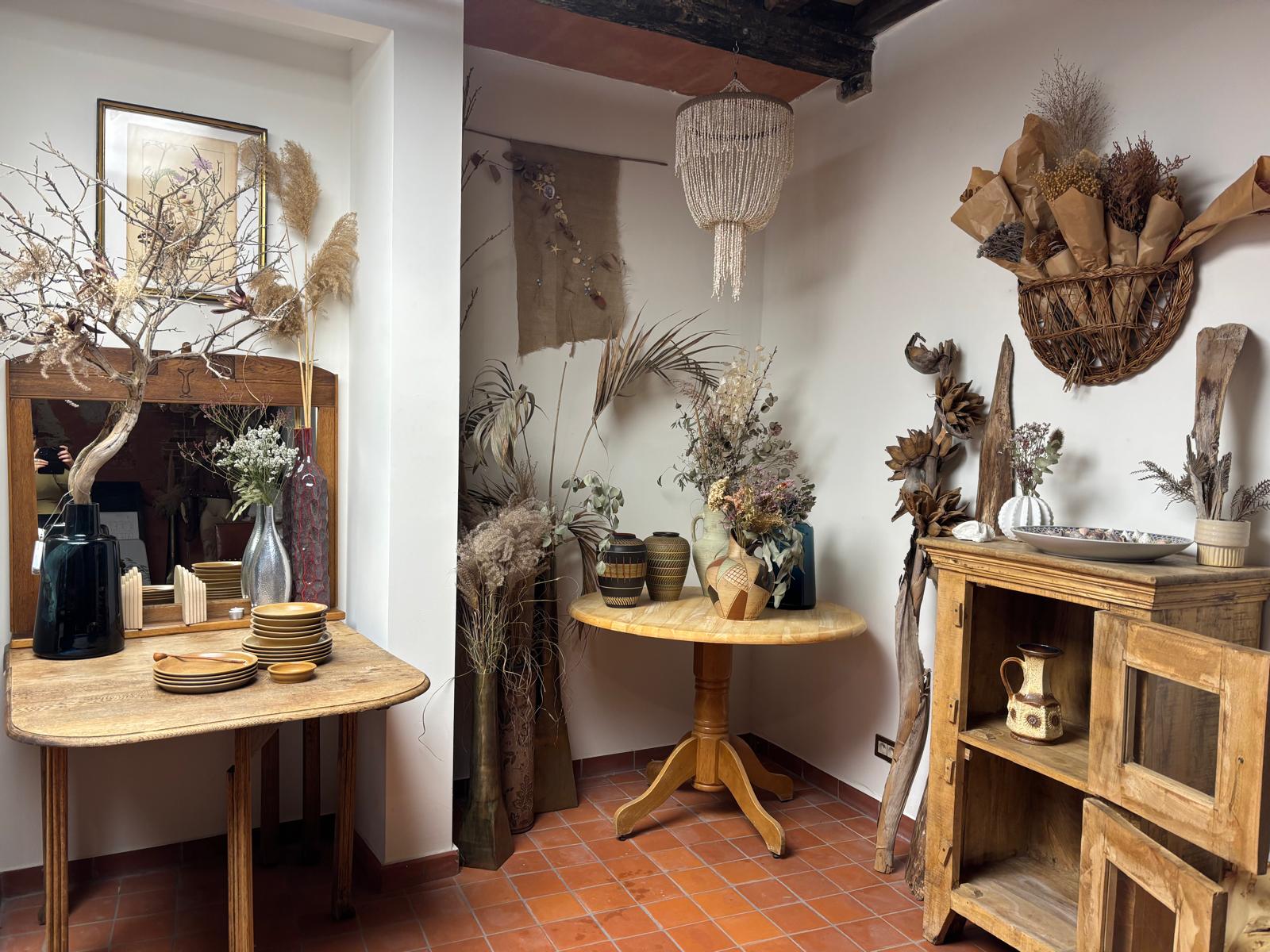 De winkel met houten kasten, vazen, drijfhout en gedroogde bloemen